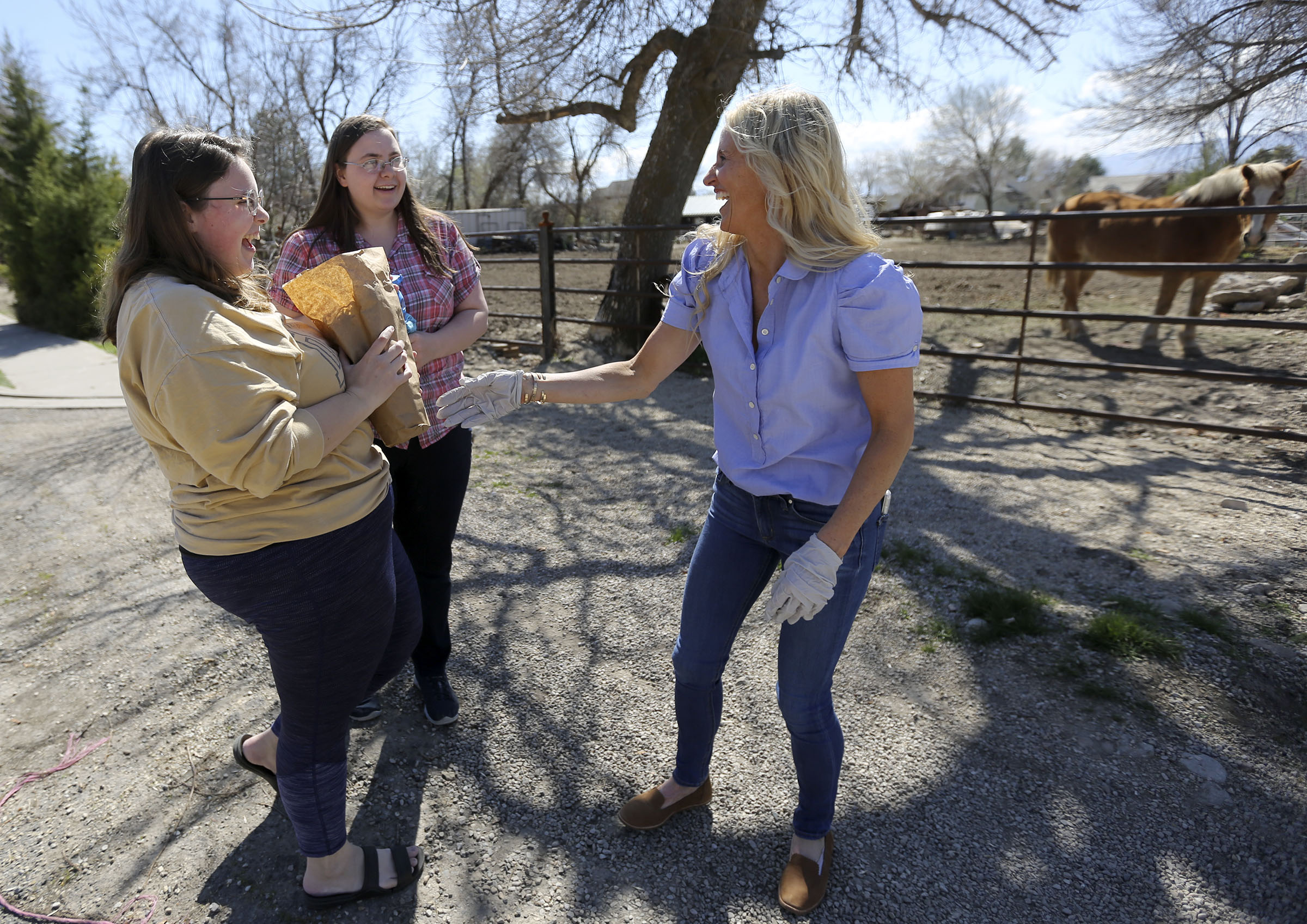 Keturah Jensen and Rebekah Jensen accept free flowers from Kelli Cloward in Provo on Friday, April 10, 2020. Due to COVID-19, Milgro Nursery had many canceled flower orders and didn’t want the flowers to go to waste, so they gave the flowers all away for free. (Photo: Kristin Murphy, KSL)