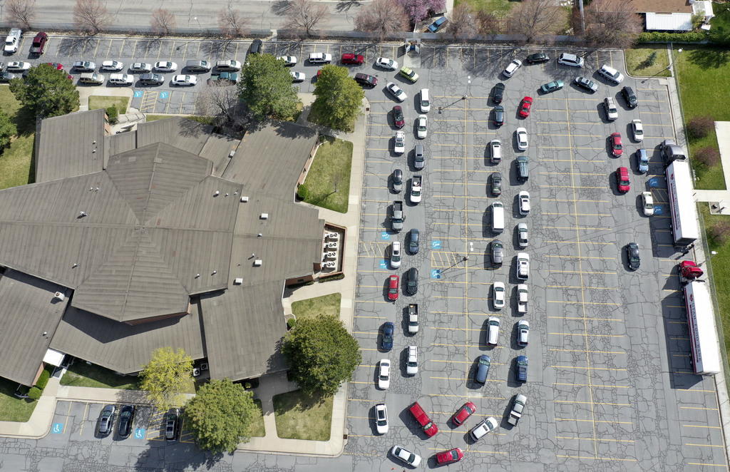 Vehicles snake around the parking lot of a chapel belonging to The Church of Jesus Christ of Latter-day Saints to pick up food from the Utah Food Bank in Taylorsville on Monday, April 13, 2020. The line continues on the street. The Utah Food Bank estimates they provided food to around 400 families at this location. (Photo: Kristin Murphy, KSL)