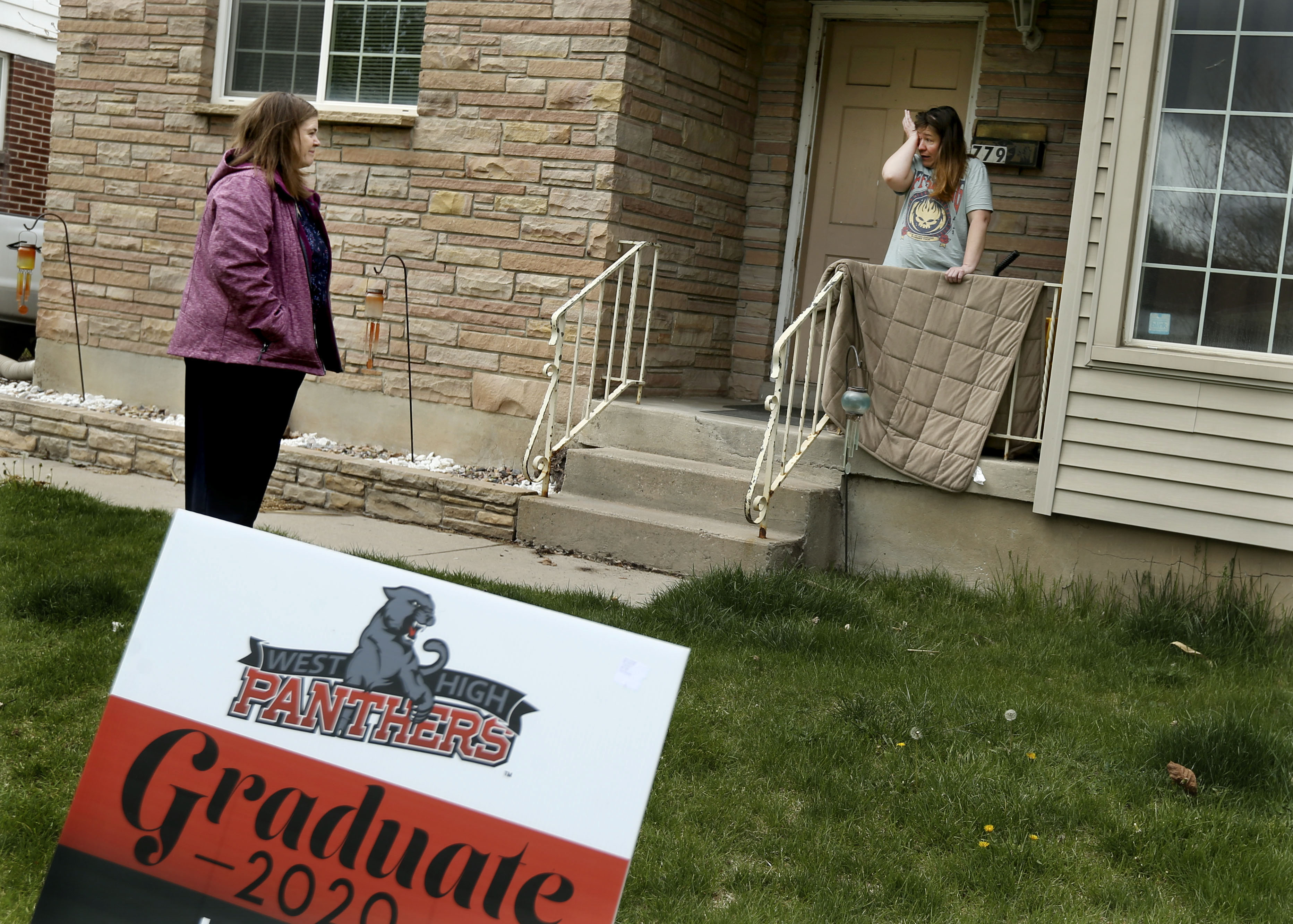 West High School teacher Kathy Barnard places a graduation sign in the yard of a senior who attends the Salt Lake City high school on Thursday, April 23, 2020. Barnard did not want the seniors to think they had been forgotten amid the coronavirus pandemic. (Laura Seitz, KSL)
