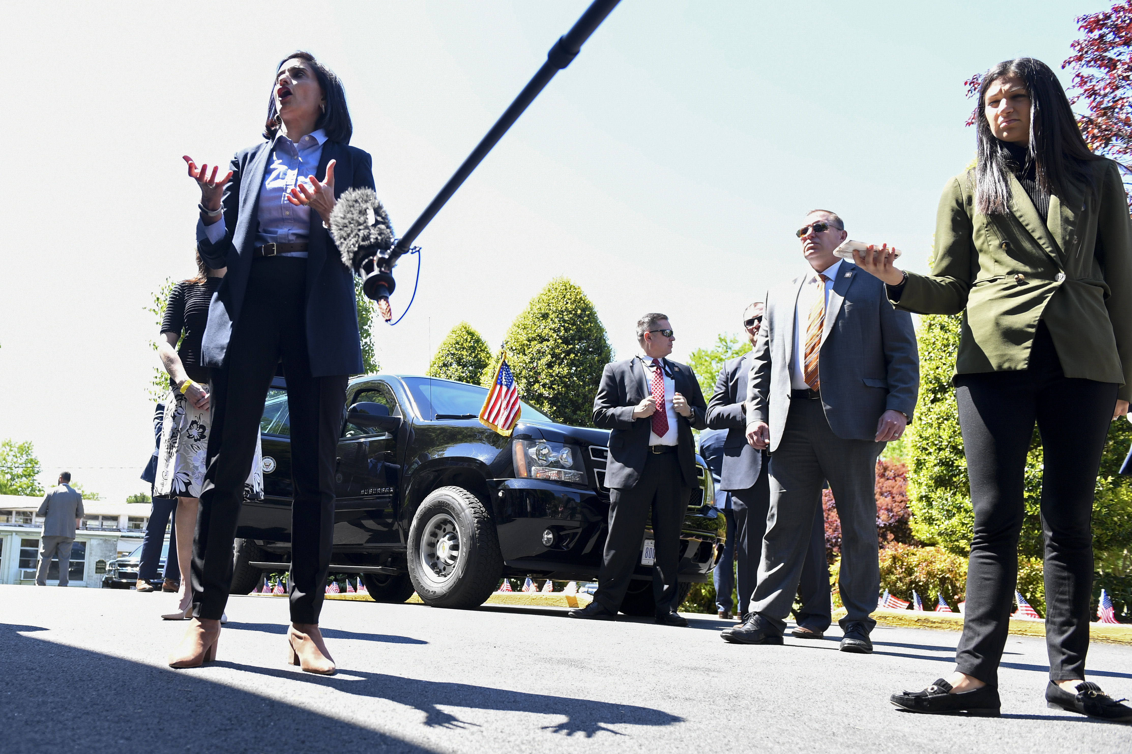In this May 7, 2020, photo, Katie Miller, press secretary for Vice President Mike Pence, right, listens as CMS Administrator Seema Verma, left, speaks during an event at Woodbine Rehabilitation and Healthcare Center in Alexandria, Va. Miller has tested positive for coronavirus. (Susan Walsh, AP Photo)