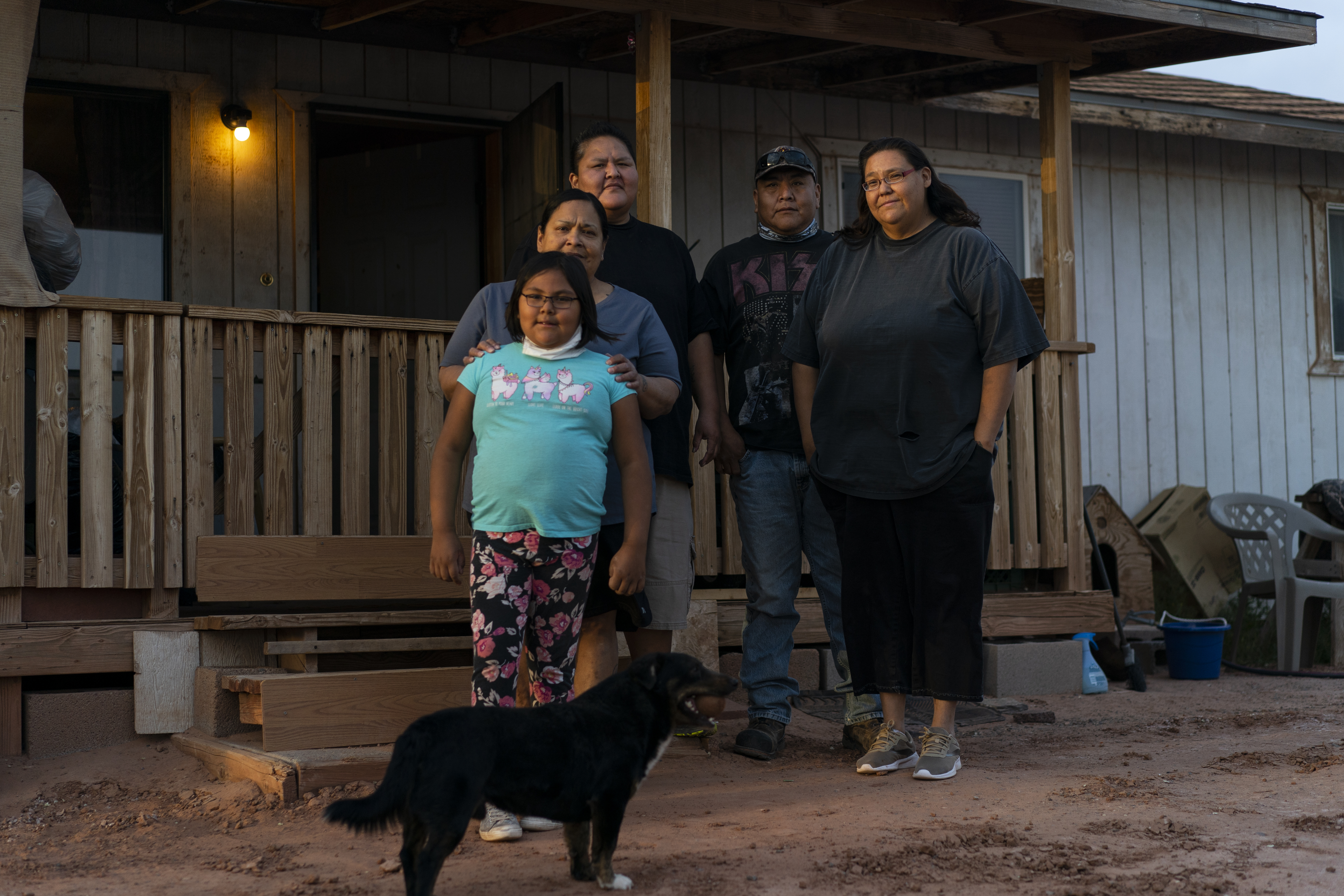 From left, Annabelle Dinehdeal, 8; Maria Cruz, Christina Dinehdeal, Eugene Dinehdeal, Angelina Dinehdeal, and their dog, Wally, pose for a photo on the Dinehdeal family compound in Tuba City, Ariz., on the Navajo reservation on April 20, 2020. (Carolyn Kaster, AP Photo)