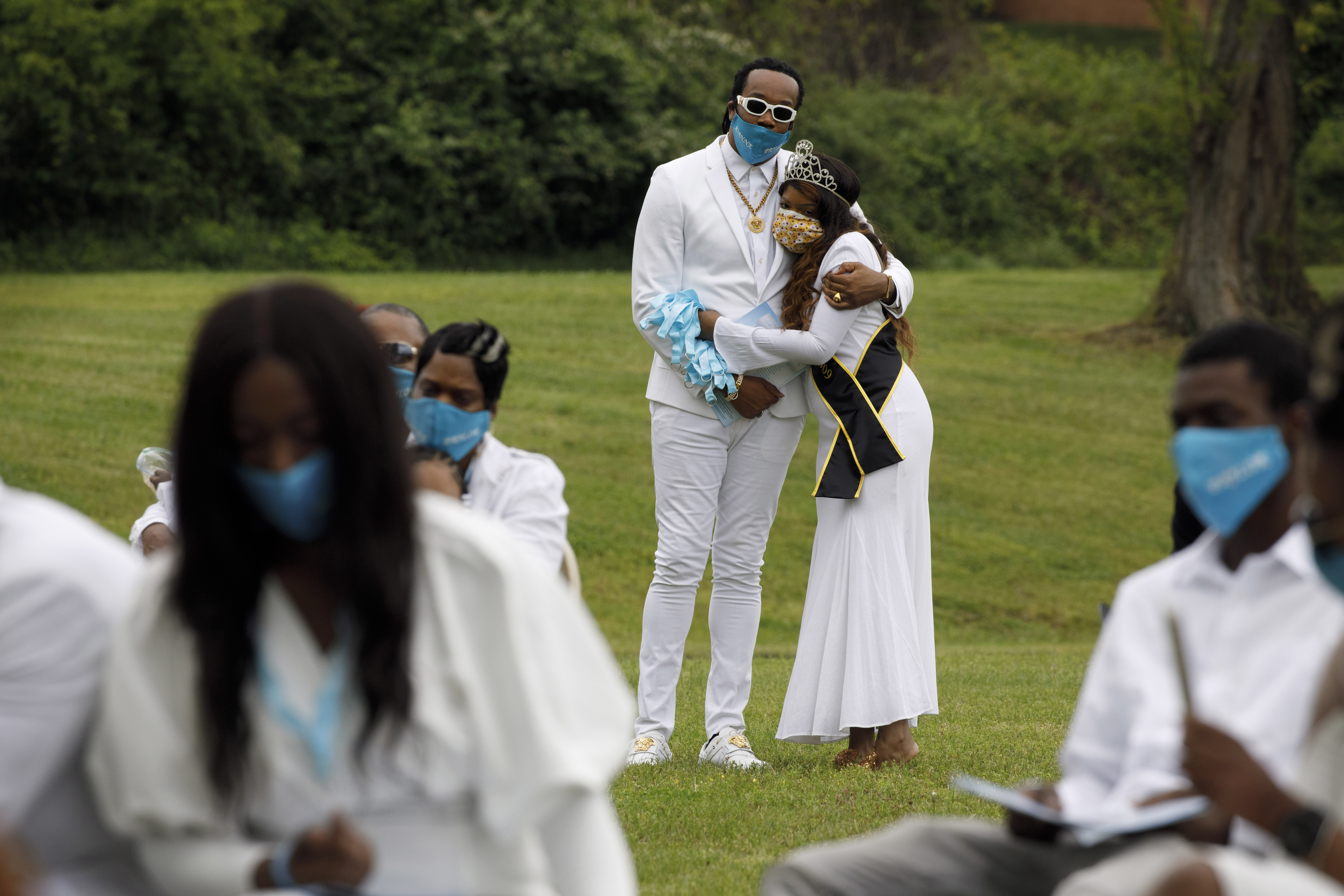 Funeral delayed: tiaras, white outfits, turquoise face masks