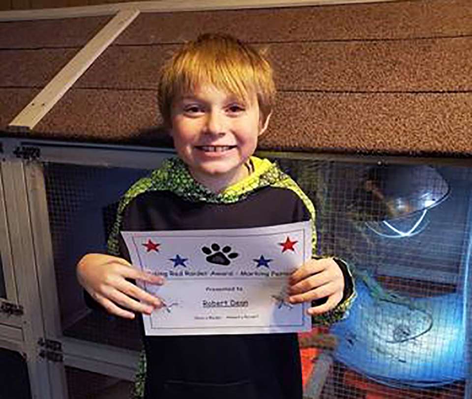 In this February 2020 photo provided by Amber Dean 9-year-old Bobby Dean holds an award he received at school in Hornell, N.Y. (Dean Family Photo via AP)