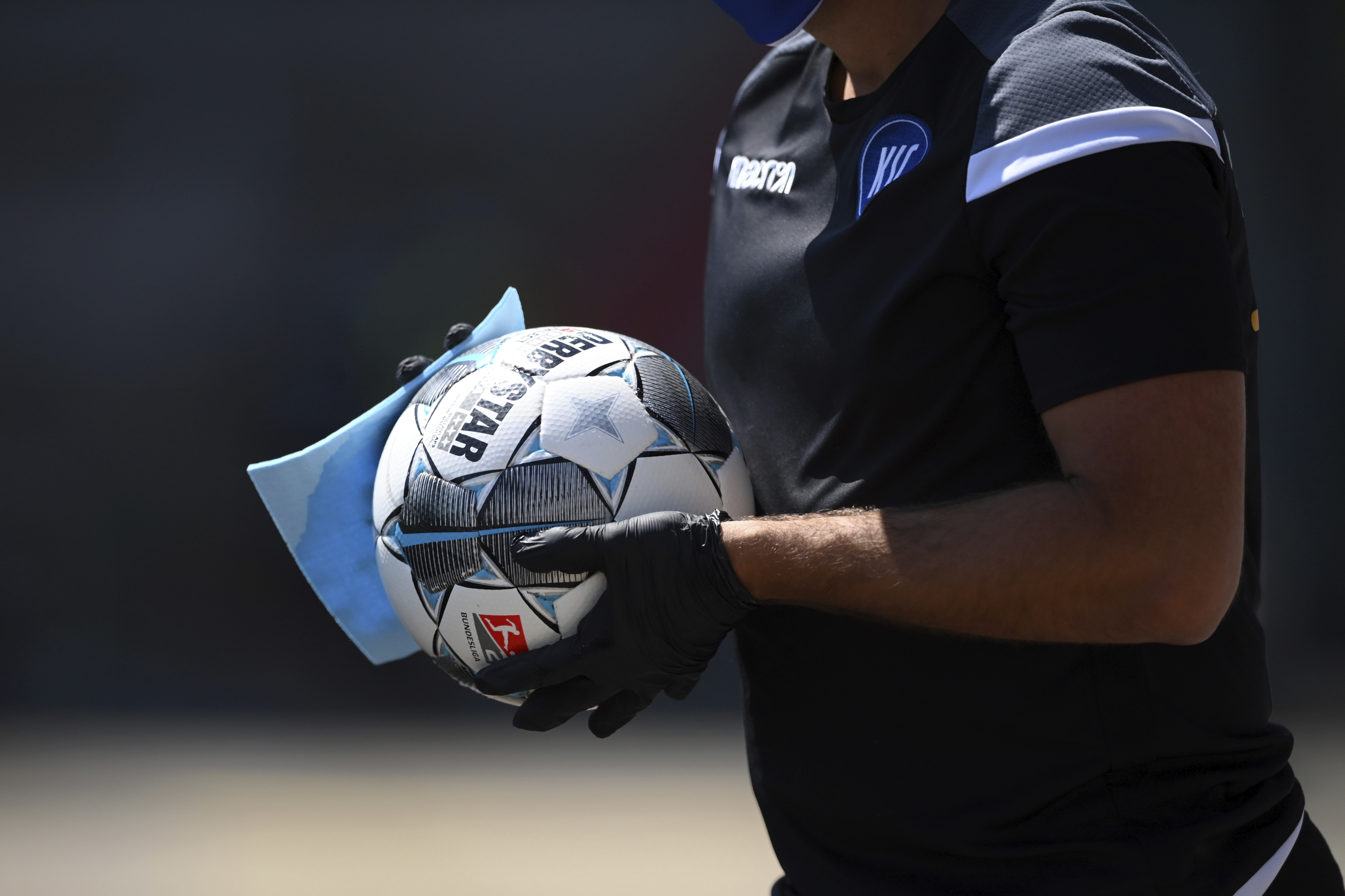 A ball boy disinfects a ball during the 2nd Bundesliga soccer match between Karlsruher SC and SV Darmstadt 98, in Karlsruhe, Germany, Saturday, May 16, 2020. Professional soccer has resumed after a two-month break in Germany with four games in the second division. (Photo: Matthias Hangst, Pool Photo via AP)