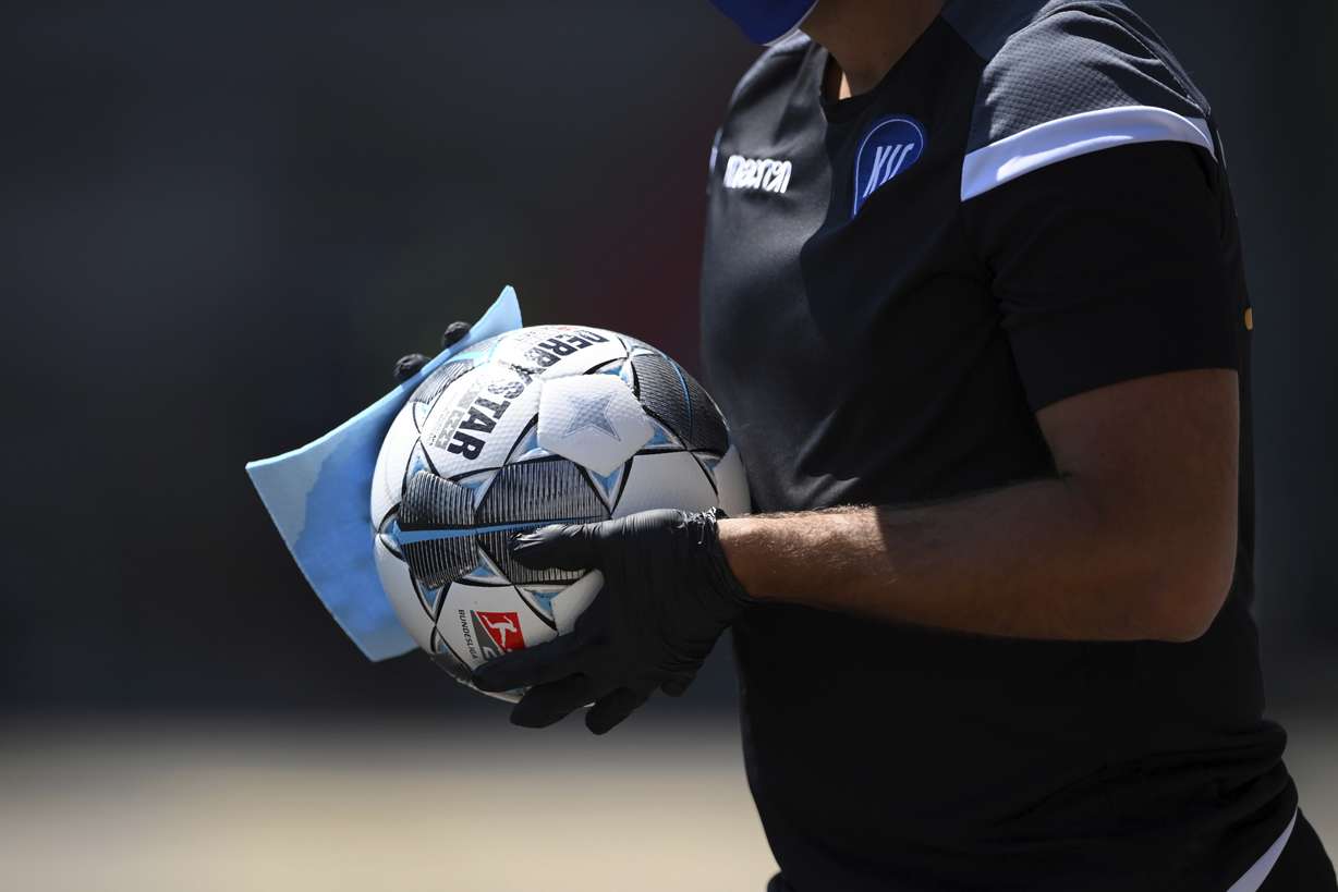 A ball boy disinfects a ball during the 2nd Bundesliga soccer match between Karlsruher SC and SV Darmstadt 98, in Karlsruhe, Germany, Saturday, May 16, 2020. Professional soccer has resumed after a two-month break in Germany with four games in the second division. (Photo: Matthias Hangst, Pool Photo via AP)