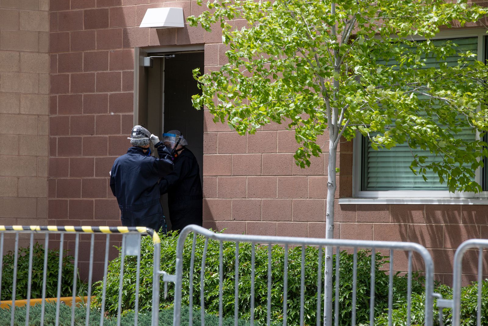 Workers in a hazmat suits stand at a barricaded doorway inside the Holladay Lions Recreation Center in Millcreek on Monday, May 18, 2020. (Photo: Ivy Ceballo, KSL)