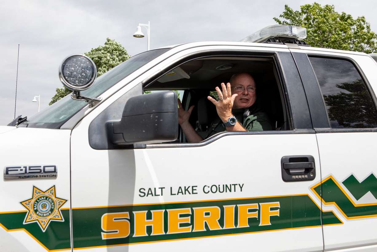 A deputy, who did not give his name, speaks to a reporter in a Salt Lake County Sheriff vehicle outside the Holladay Lions Recreation Center in Millcreek on Monday, May 18, 2020. “It’s a county facility so we’re just here to make sure it’s safe,” he said. (Photo: Ivy Ceballo, KSL)