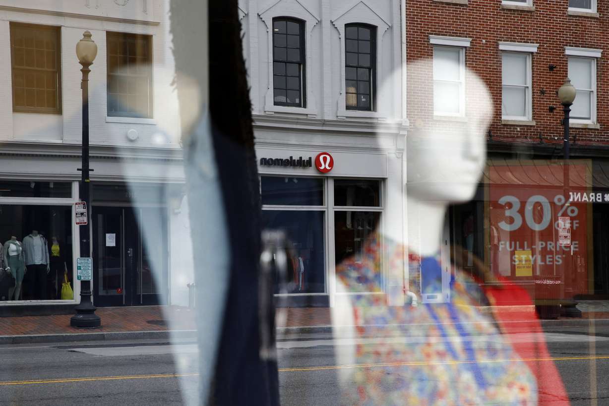 Closed stores are reflected in a window in the Georgetown neighborhood of Washington, Thursday, May 21, 2020. (AP Photo/Patrick Semansky)