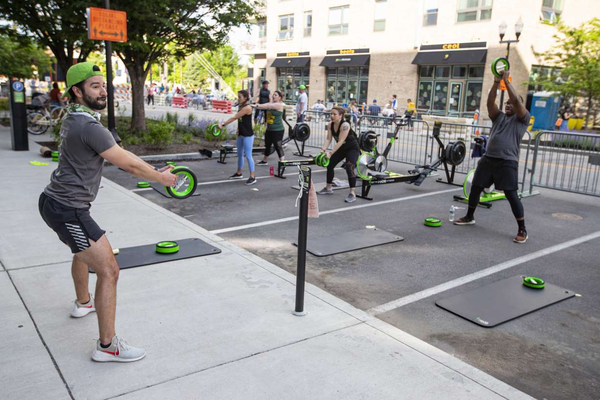 Jacob Morden leads a fitness class on a closed street in downtown Indianapolis, Friday, May 22, 2020. The city closed several streets to traffic to accommodate larger outdoor areas for restaurants to provide for social distancing and the gym was able to take advantage of the closure to teach outdoor class. Gym as not yet allowed to open. (AP Photo/Michael Conroy)
