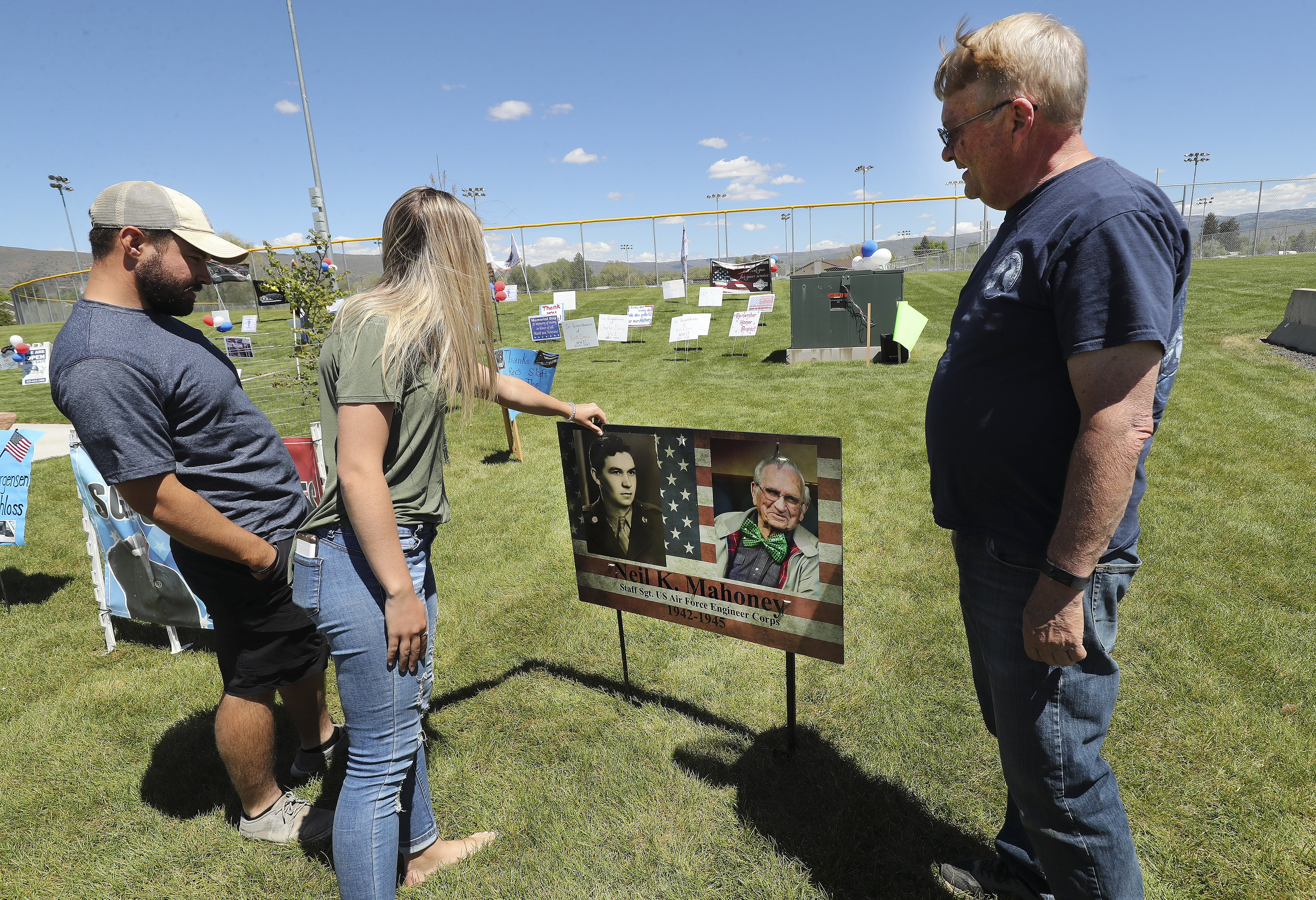 Kent Mahoney, son of veteran Neil Mahony, and his children Branson and Kaylee look over his photos at Veterans Memorial Park in Heber during a daylong drive-by tribute for veterans on Memorial Day, Monday, May 25, 2020. (Photo: Jeffrey D Allred, KSL)