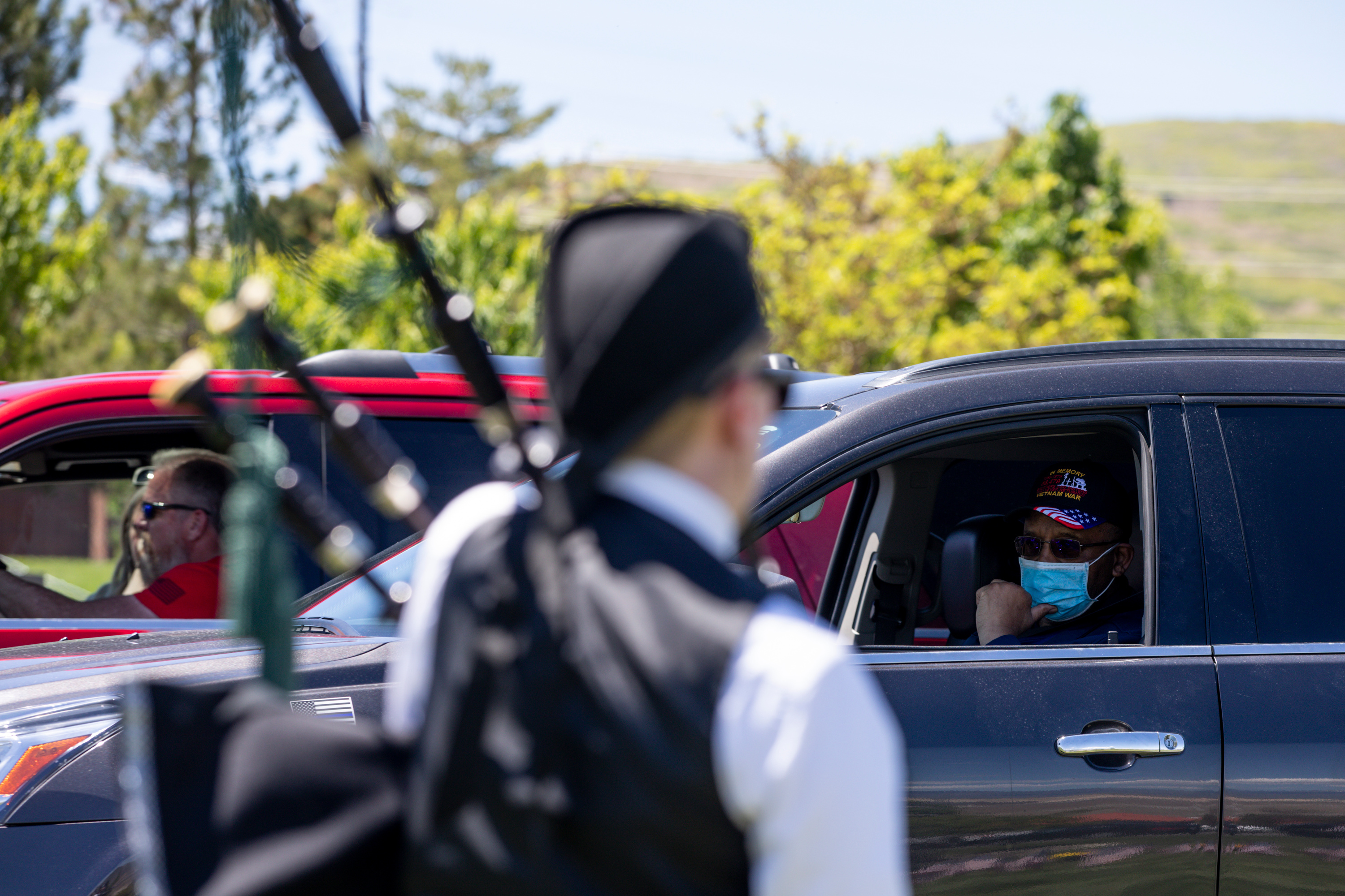 Jim Coleman, a veteran, listens from his car as Megan Kennedy plays “Amazing Grace” on a set of bagpipes at Utah Veterans Cemetery and Memorial Park in Bluffdale on Memorial Day, Monday, May 25, 2020. (Photo: Ivy Ceballo, KSL)