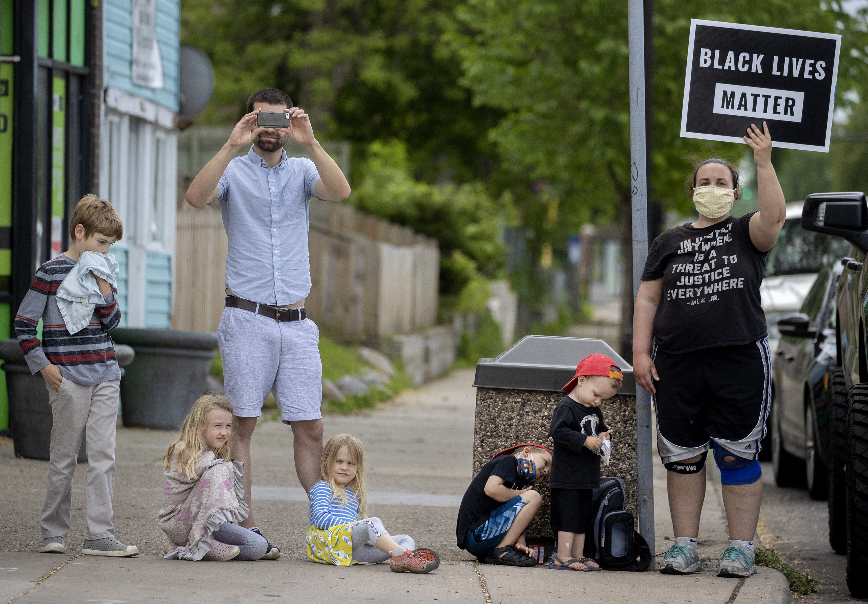 A person holds a sign in protest, Tuesday, May 26, 2020, in Minneapolis, near the site where a black man, who was taken into police custody the day before, later died. (Elizabeth Flores, Star Tribune via AP)