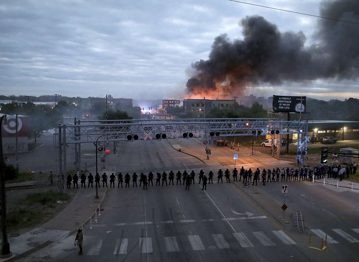 Law enforcement officers amassed along Lake Street near Hiawatha Ave. as fires burned after a night of unrest and protests in the death of George Floyd early Friday, May 29, 2020 in Minneapolis. (Photo:David Joles/Star Tribune via AP)