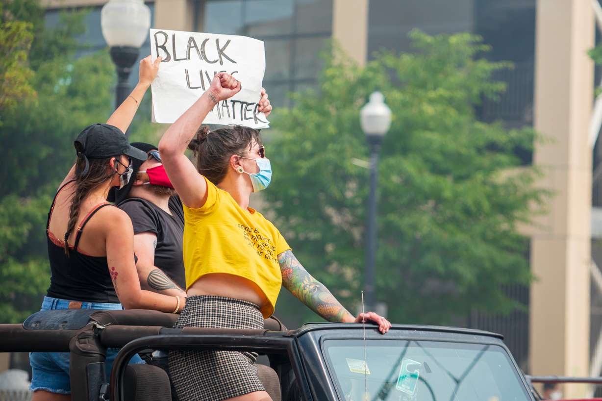 Demonstrators hold up signs during a protest against police brutality in downtown Salt Lake City on Saturday, May 30, 2020. The protest is one of many across the nation to denounce the death of George Floyd, a black man who died while being taken into custody by a Minneapolis police officer earlier this week.