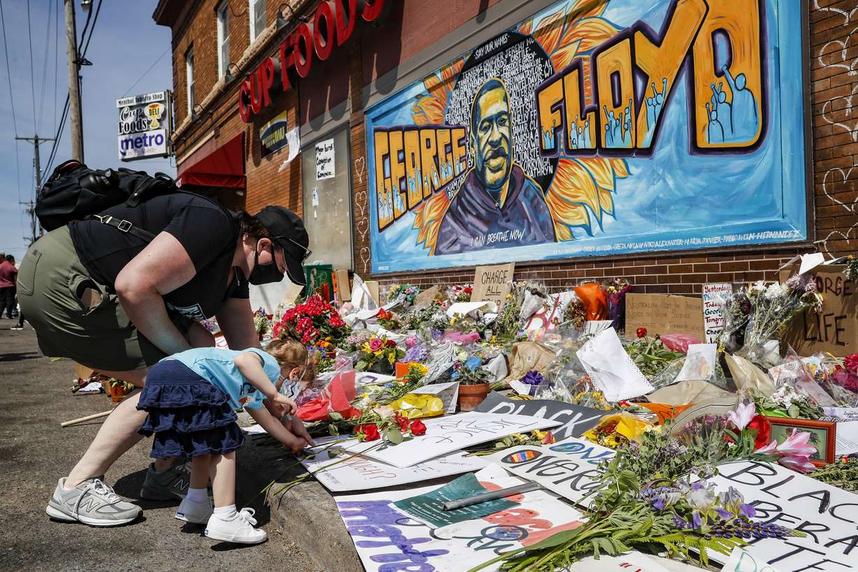 Jessica Knutson, and her daughter Abigail, 3, place flowers at a memorial to George Floyd, Sunday, May 31, 2020, in Minneapolis. Protests continued following the death of Floyd, who died after being restrained by Minneapolis police officers on May 25. (John Minchillo, AP Photo)