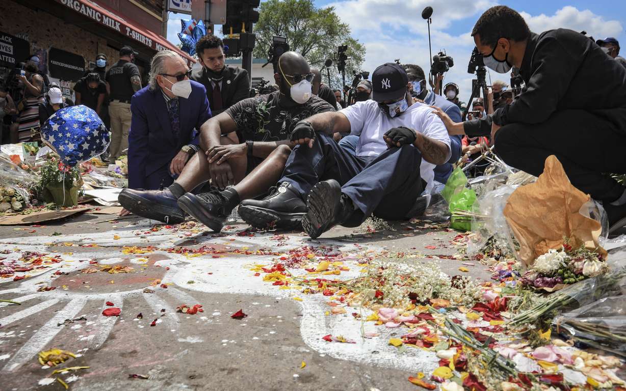 An emotional Terrence Floyd, second from right, is comforted as he sits at the spot at the intersection of 38th Street and Chicago Avenue, Minneapolis, Minn., where his brother George Floyd, encountered police and died while in their custody, Monday, June 1, 2020. (Bebeto Matthews, AP Photo)