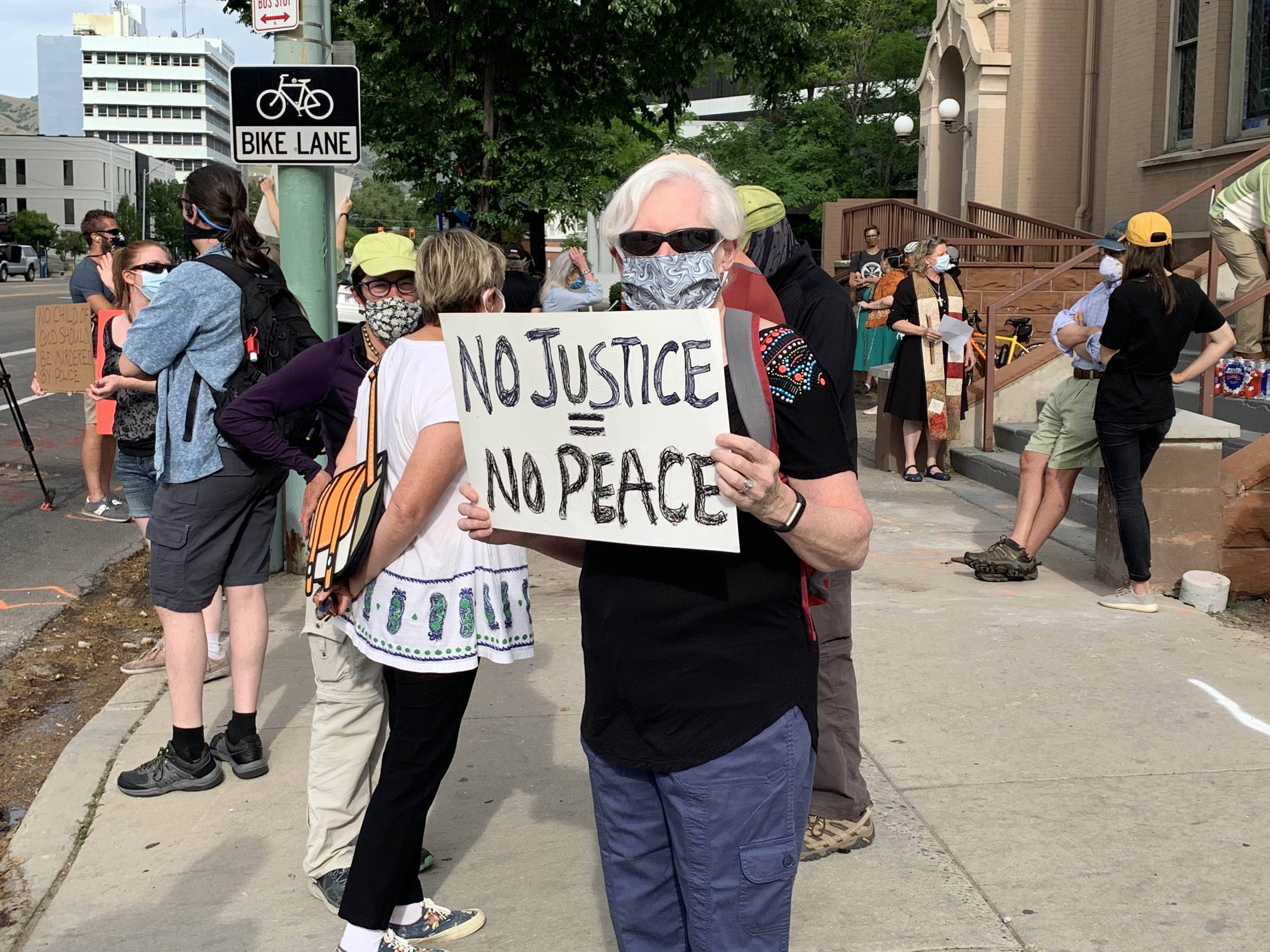 A protestor stands on the corner of the First United Methodist Church in downtown Salt Lake City during a rally. (Ryan Miller/KSL.com)