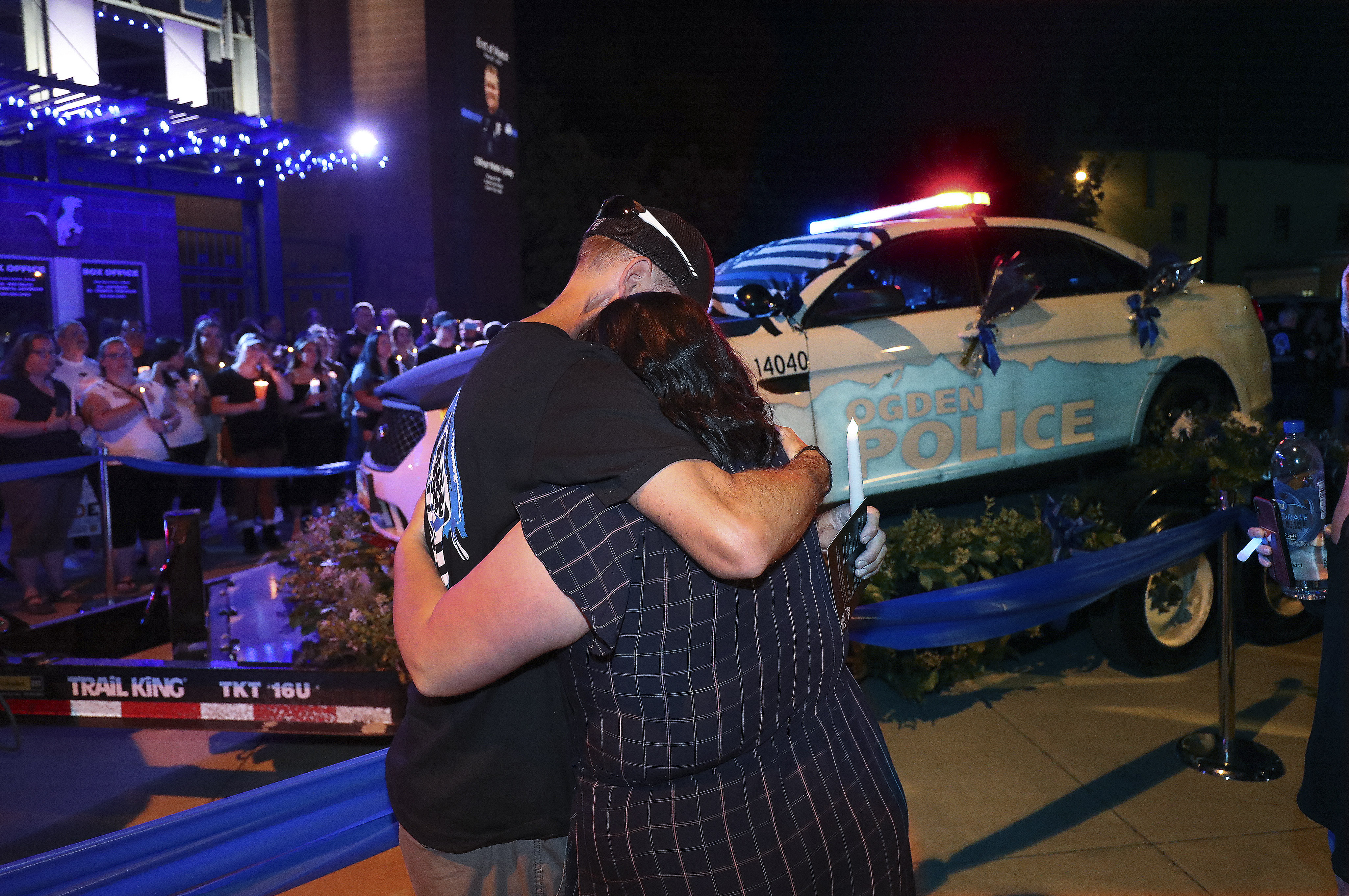 Ogden police officer Jason Vanderwarf hugs Ashley Lyday, widow of Ogden police officer Nate Lyday, near Lyday's patrol car during a candlelight vigil in Ogden on Thursday, June 4, 2020. Lyday was shot and killed May 28 in the line of duty. (Jeffrey D. Allred, KSL)