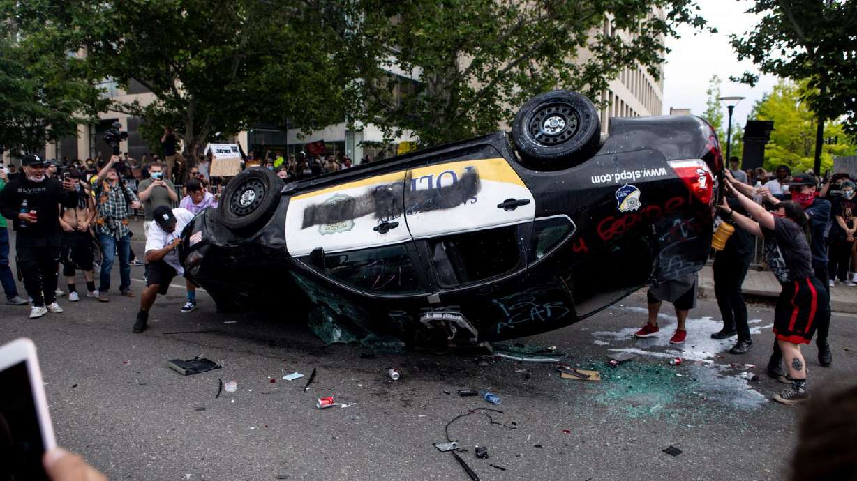 A Salt Lake City Police Department patrol car is overturned during a protest in downtown Salt Lake City on May 30, 2020. A man who admitted to helping overturn and burn the car was sentenced this week to two years in federal prison in the case.