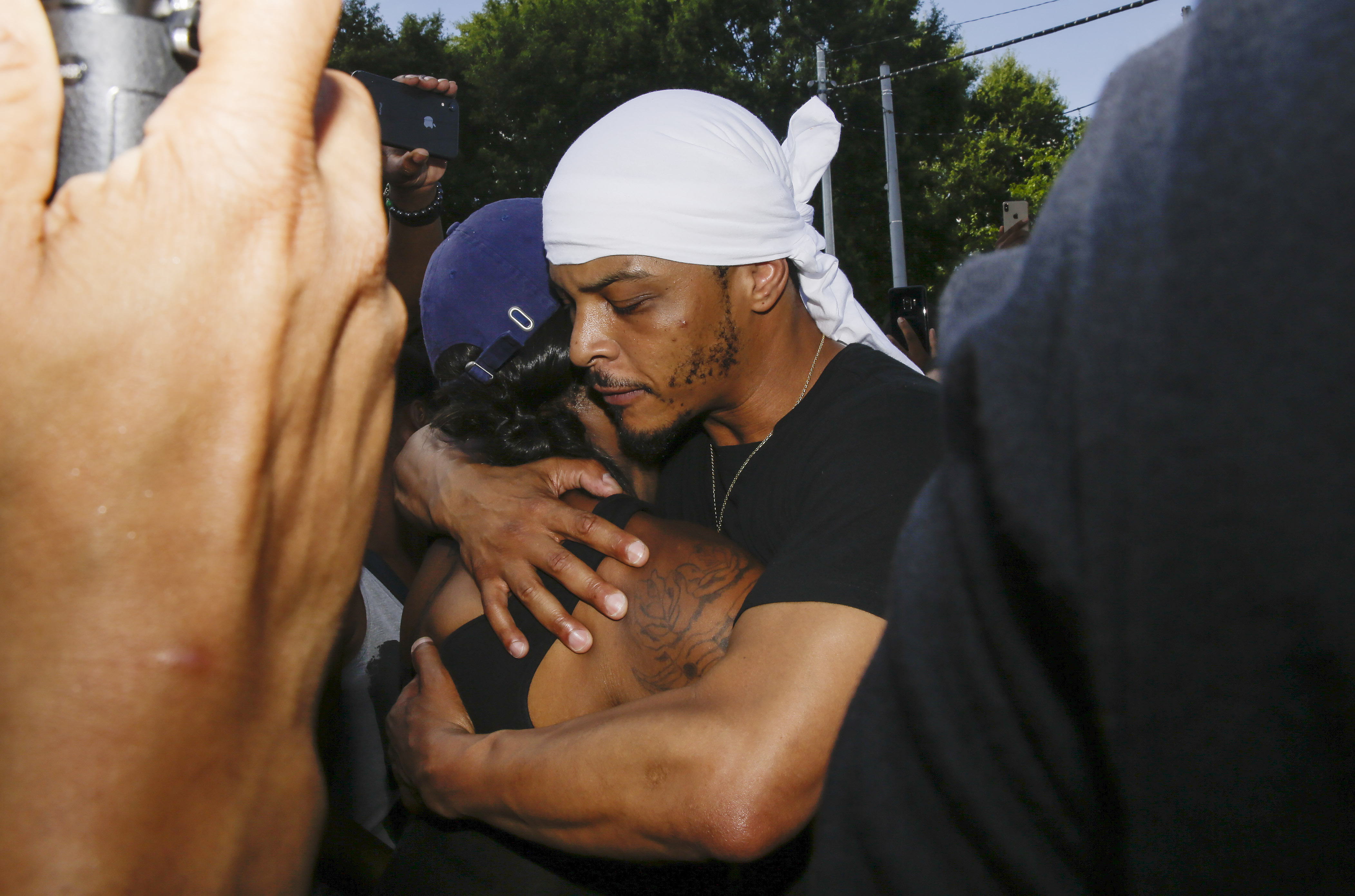 Rapper T.I. hugs a family member of Rayshard Brooks during protests, Saturday, June 13, 2020, near the Wendy's restaurant where Brooks was shot and killed by police Friday evening following a struggle in the restaurant's drive-thru line in Atlanta. (Brynn Anderson, AP Photo)