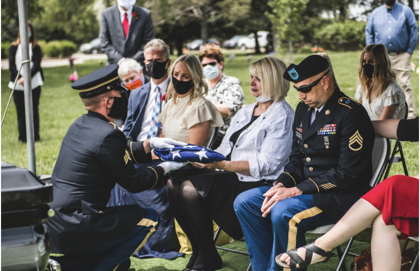 A soldier hands the U.S. flag from Ken Kirkman’s casket to Karen Kirkman. (Photo: Trisha Terry via KSL TV)