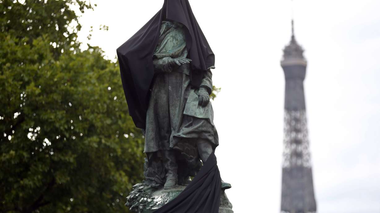 Paris protesters cloak colonial-era statue with black cloth