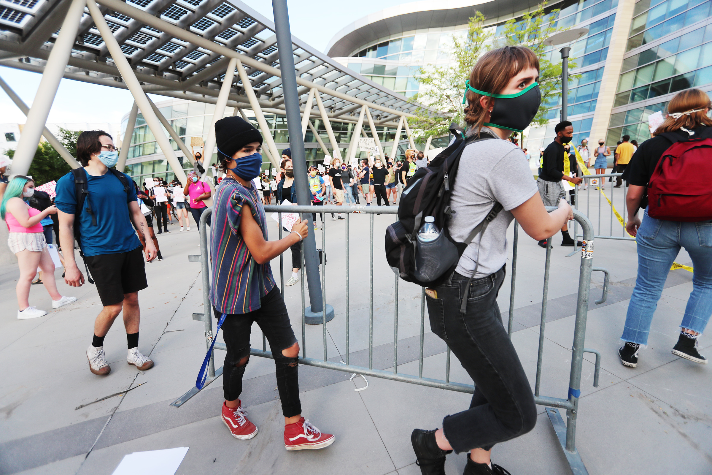 Two demonstrators carry a barricade to a pile as over 150 demonstrators gather at the Public Safety Building as they walk the streets of Salt Lake City chanting and holding signs on Wednesday, June 24, 2020. (Scott G Winterton, KSL)
