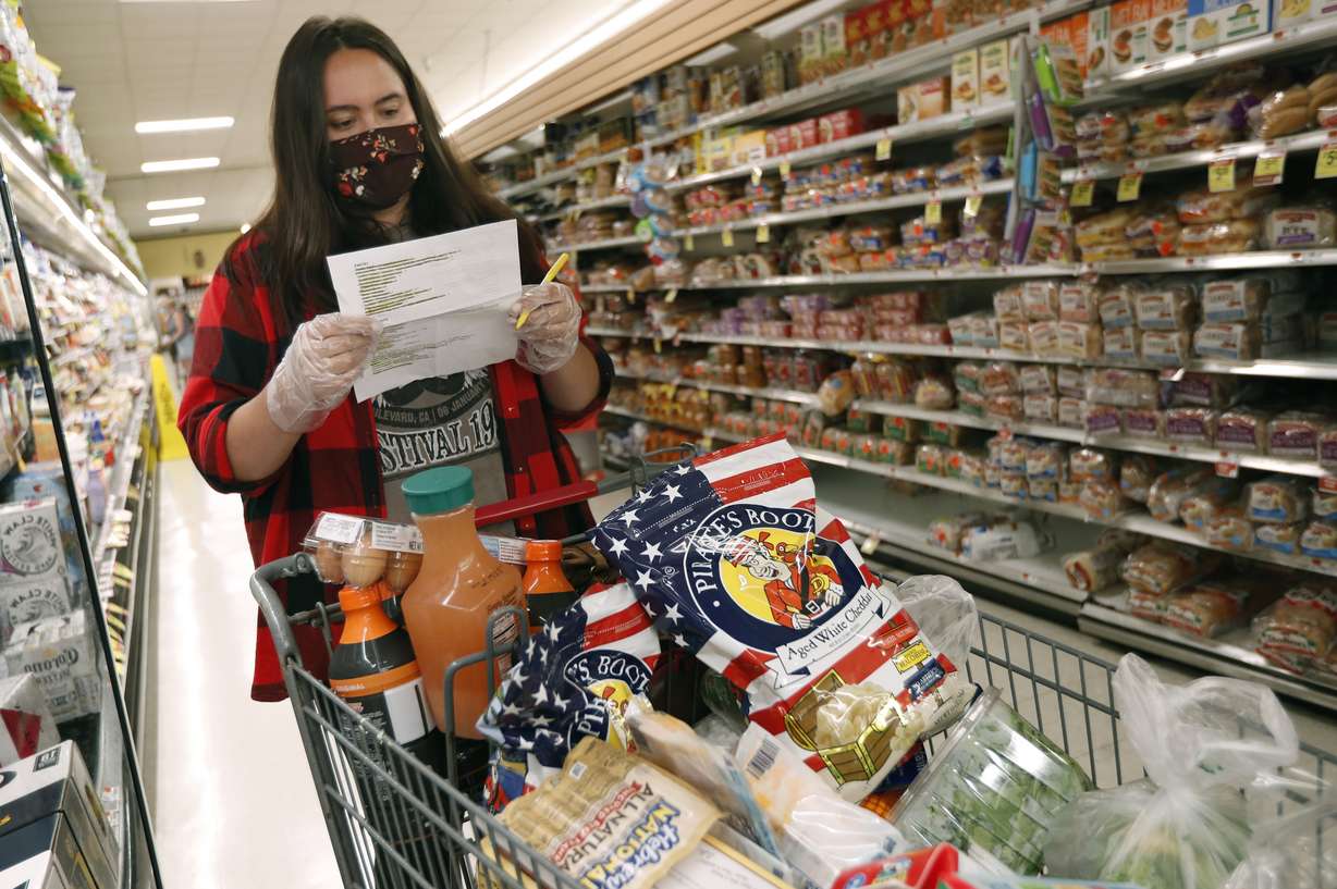 Alexandra Lopez-Djurovic checks her shopping list as she shops for a client in an Acme supermarket, Wednesday, July 1, 2020, in Bronxville, N.Y. Lopez-Djurovic was working full time as a nanny until her hours were cut substantially due to the coronavirus pandemic, so she started her own grocery delivery service that made up for some of her lost wages, but not all. (Photo: Kathy Willens, AP Photo)