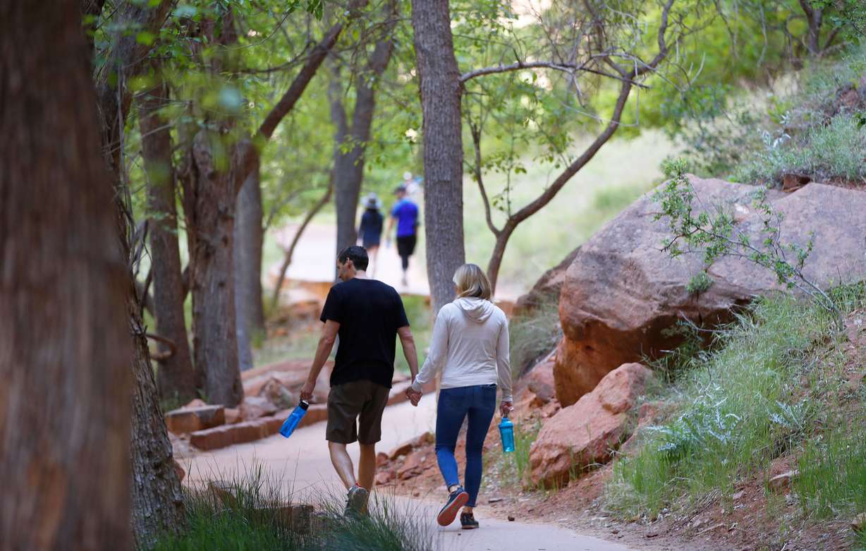 Hikers walking along a paved trail in Utah's Zion National Park, Utah, which had been closed due to the pandemic. (Photo: George Frey, Getty Images)