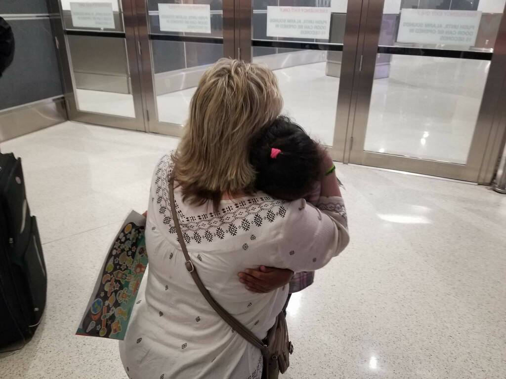 Laurie Holt embraces Nathalia, the daughter of Thamy Holt, on her arrival in the United States in February 2018.