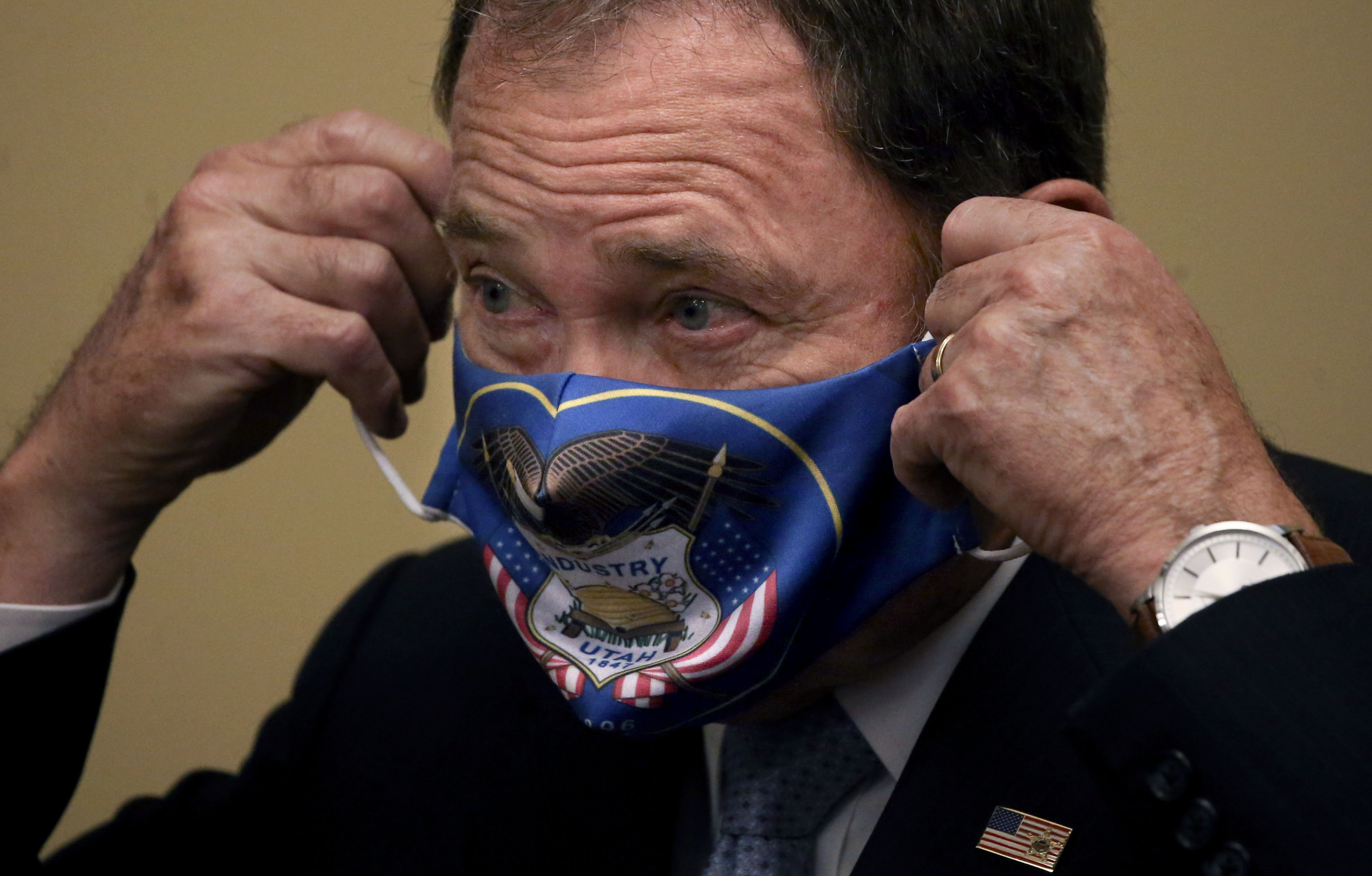 Gov. Gary Herbert puts on a face mask after speaking at a press conference at the Capitol in Salt Lake City on Thursday, July 9, 2020. The governor announced that he is expanding face mask requirements to all schools, but he did not make a general requirement statewide.