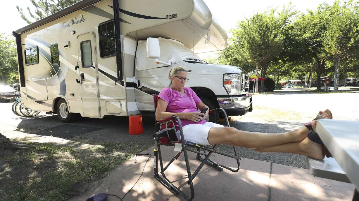 Chris Clark, of Orlando, Fla., relaxes by her RV at the KOA campground in Salt Lake City on Thursday, July 9, 2020.