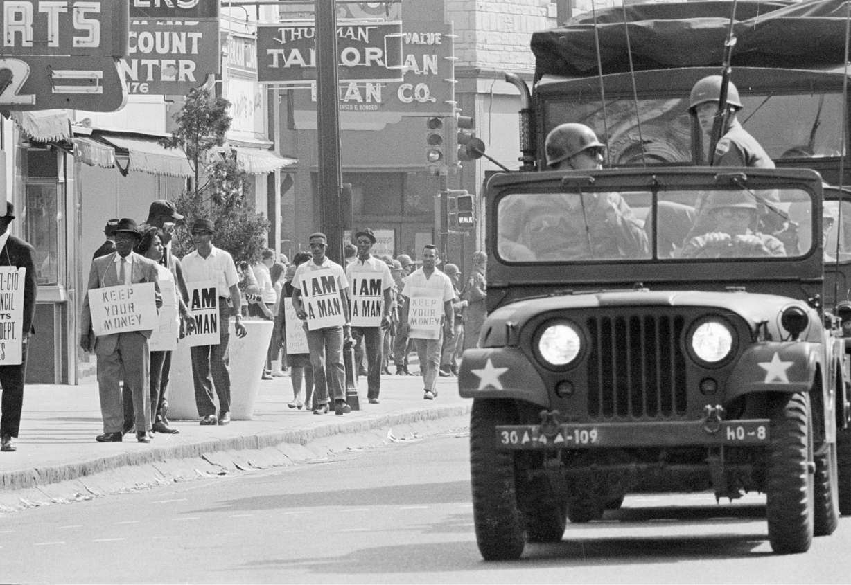 n this March 30, 1968 file photo, Tennessee National Guard troopers in jeeps and trucks escort a protest march by striking Memphis sanitation workers through downtown Memphis, Tenn. (AP Photo, File)