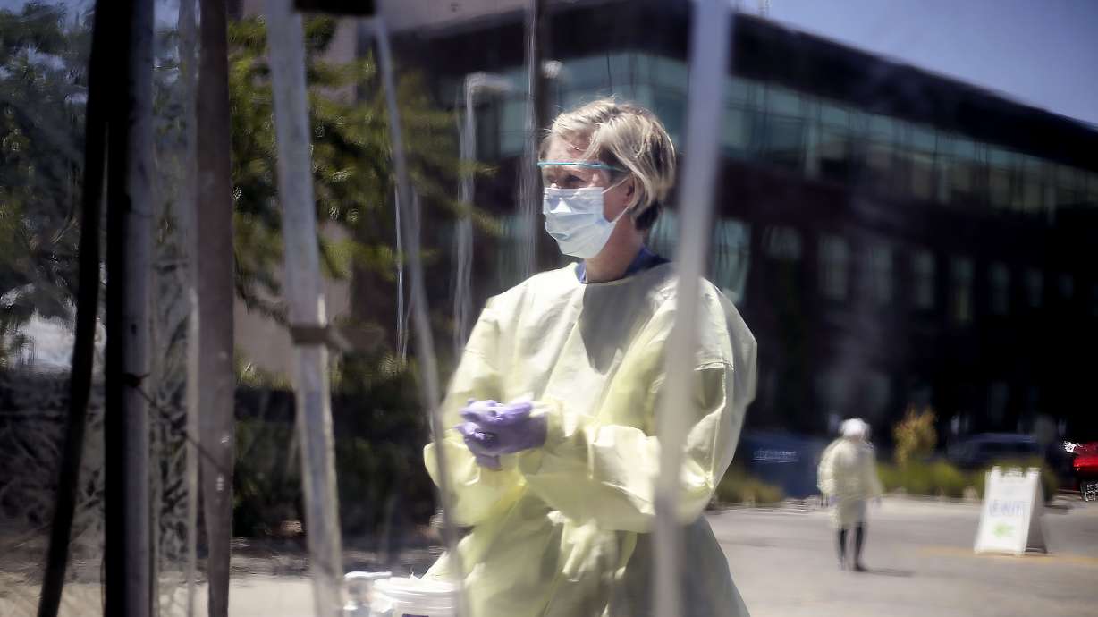 Registered nurse Beth Ann Friel sanitizes her hands at a COVD-19 test center at Intermountain Healthcare's Salt Lake Clinic on Friday, July 10, 2020. Officials from Intermountain Healthcare, University of Utah Health, MountainStar Healthcare and Steward Health Care fear that if COVID-19 cases continue to spike, they will no longer be able to effectively manage all the patients.