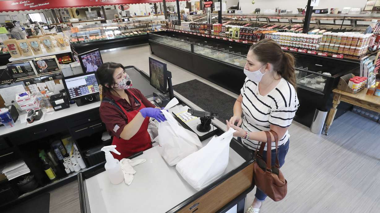 Kami Ilizaliturri, right, makes a purchase from Ana Vargas at Snider Bros. Meats in Holladay on Thursday, June 25, 2020. The store currently requires all customers to wear a mask while shopping.