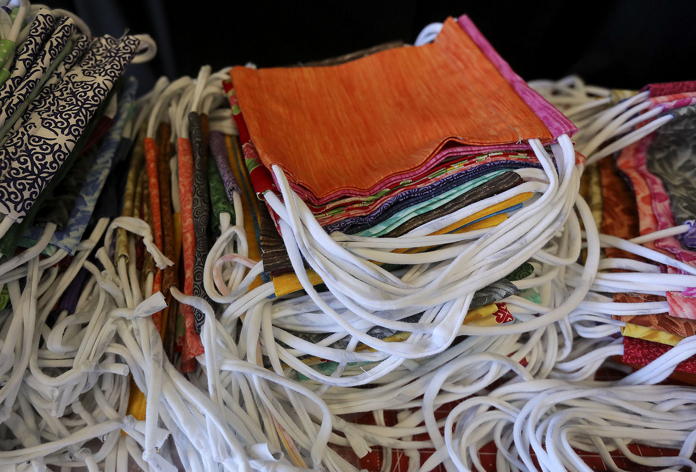 Completed face masks are stacked in a pile at the Viridian Library in West Jordan on Tuesday, July 7, 2020. Salt Lake County and Stitching Hearts Worldwide have partnered to make 250,000 face masks with the help of volunteers.