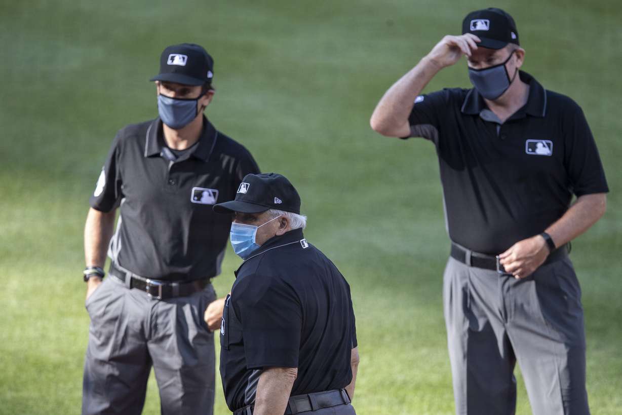 The umpires, wearing face masks, gather before an exhibition baseball game between the Washington Nationals and the Philadelphia Phillies at Nationals Park, Saturday, July 18, 2020, in Washington. (Alex Brandon, AP Photo)