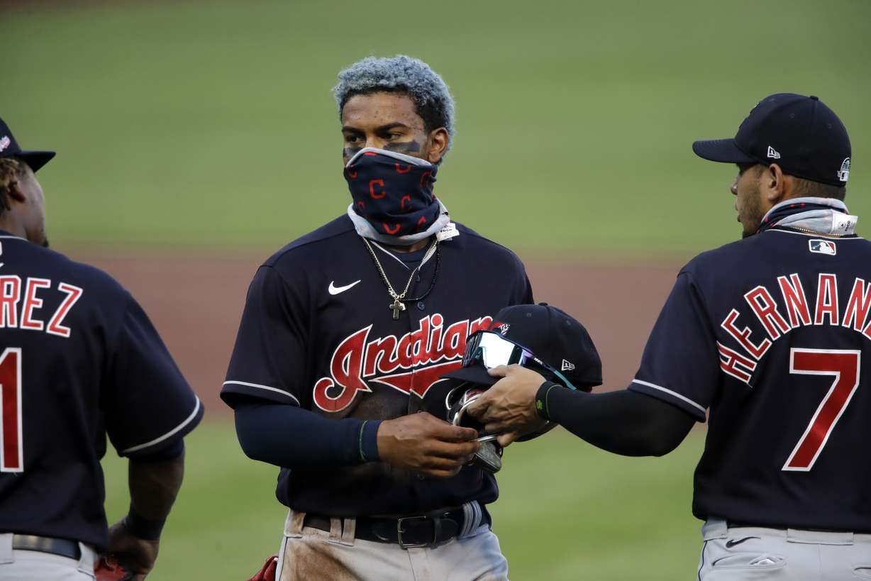 Cleveland Indians' Francisco Lindor, center, gets his glove and cap from Cesar Hernandez (7) at the end of the first inning of an exhibition baseball game against the Pittsburgh Pirates in Pittsburgh, Saturday, July 18, 2020. (Gene J. Puskar, AP Photo)