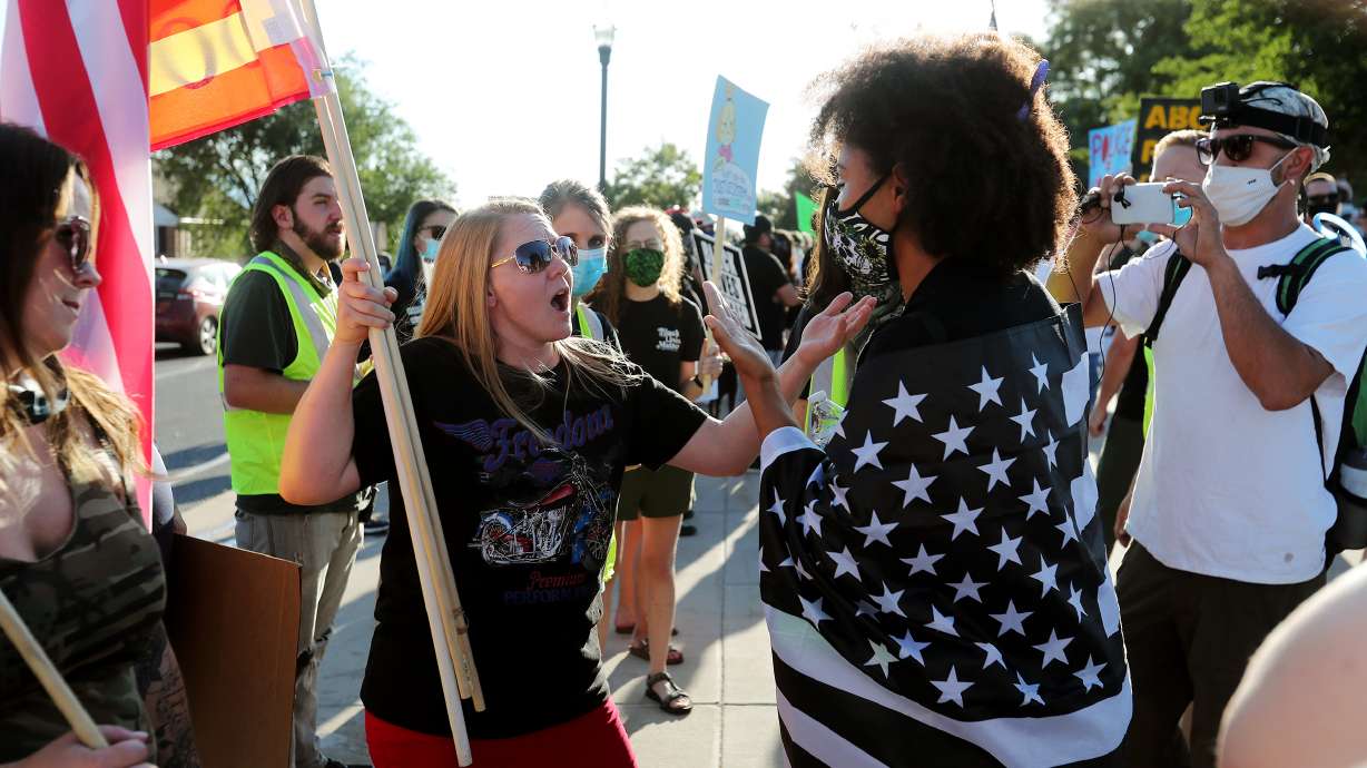 Heather, who did not provide a last name, from Patriots Prepared, and Rae Duckworth of Black Lives Matter debate outside the Capitol in Salt Lake City on Saturday, July 18, 2020. One group of protesters had met to oppose police brutality and to call for Gov. Gary Herbert to repeal HB415; they were met by a small group of counter protesters.