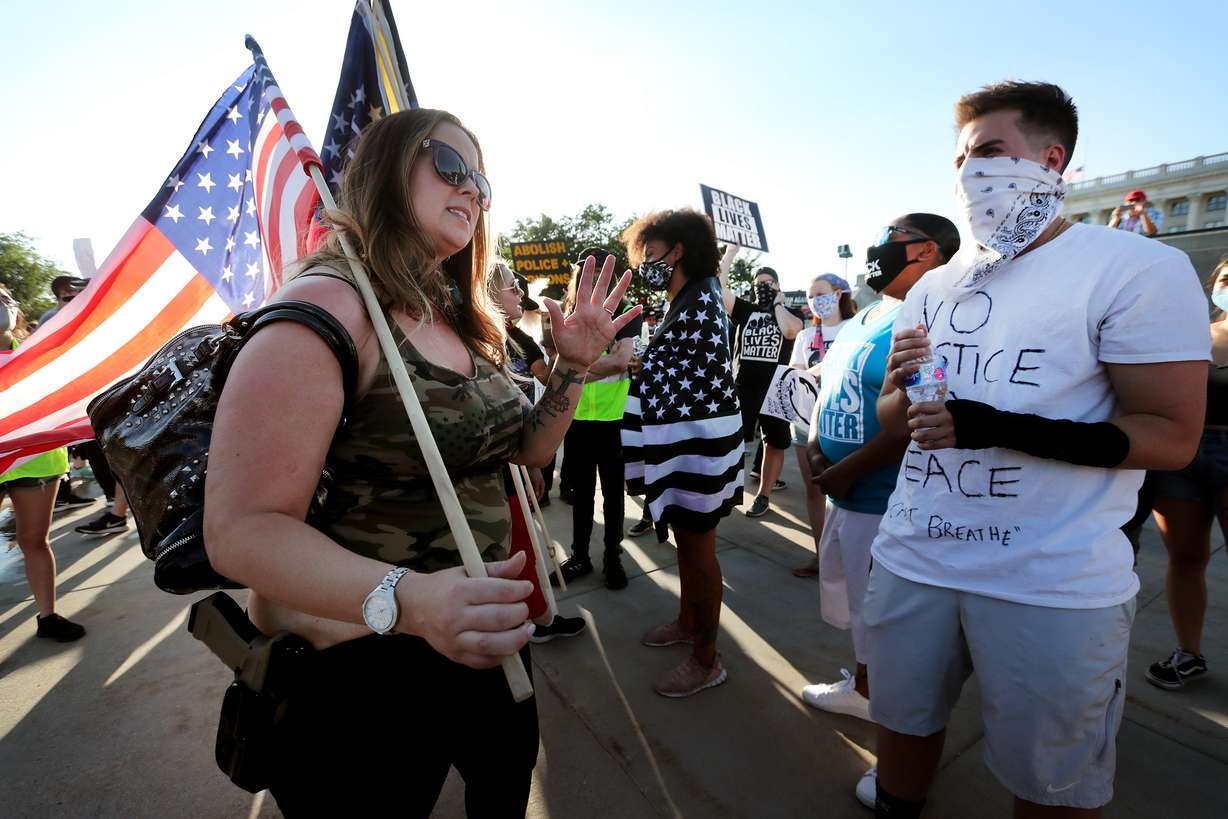 Jamie, who did not provide a last name, from Patriots Prepared, and Drew Kacey debate outside the Capitol in Salt Lake City on Saturday, July 18, 2020. One group of protesters had met to oppose police brutality and to call for Gov. Gary Herbert to repeal HB415; they were met by a small group of counter protesters.