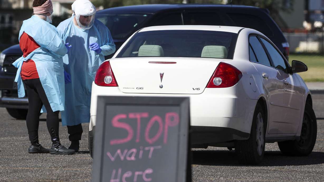 Ashley Cameron, left, and Dakota Silva, with University of Utah Health, test people for COVID-19 during the University of Utah’s Wellness Bus drive-thru testing event at Centennial Park in West Valley City on Monday, July 6, 2020.