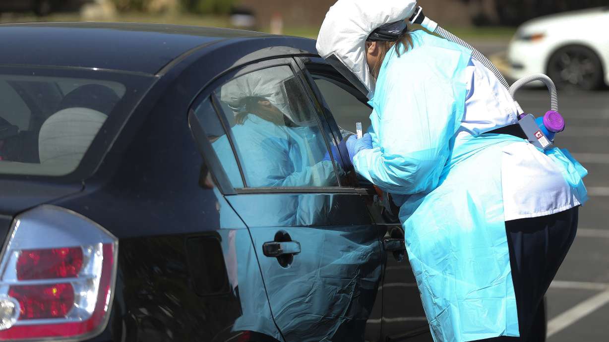 Registered nurse Sarah Smith tests a patient for COVID-19 as University of Utah Health's Wellness Bus visits a neighborhood in West Valley City on Wednesday, July 15, 2020. The 40-foot RV was specially designed to travel to underserved neighborhoods to provide health consultations, screenings and education.