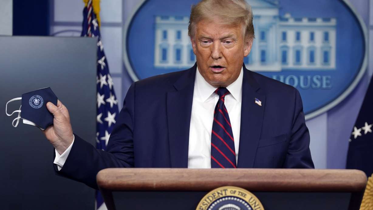 President Donald Trump holds a face mask as he speaks during a news conference at the White House, Tuesday, July 21, 2020, in Washington.