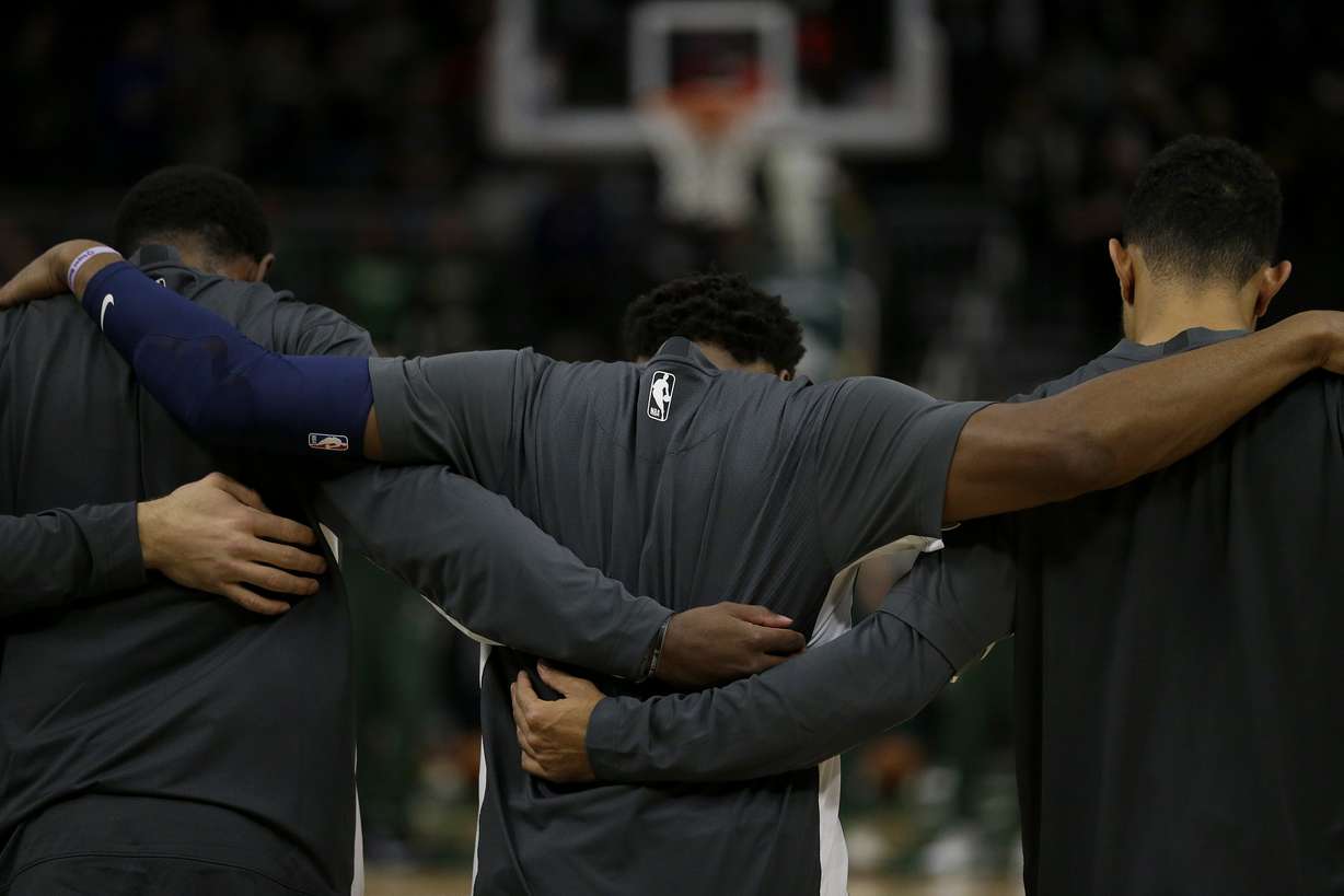 Utah Jazz's Donovan Mitchell, middle, puts his arms around teammates before a preseason NBA basketball game against the Milwaukee Bucks Wednesday, Oct. 9, 2019, in Milwaukee.