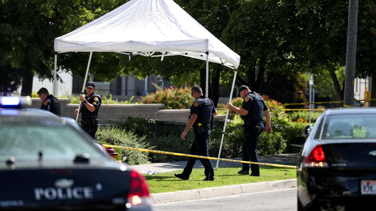 Law enforcement officers set up a shade to place over the body of a man shot and killed by Salt Lake City police officers on 500 South in Salt Lake City on Saturday, July 25, 2020. A police spokesperson said two officers responded to a call of a knife fight between two men that resulted in the officers shooting and killing one of the men.