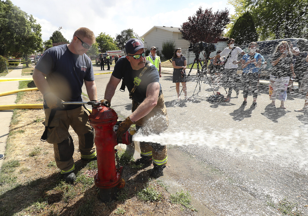 West Jordan Fire Department shuts down a fire hydrant after working at the scene where an airplane crashed into houses in West Jordan on Saturday, July 25, 2020.