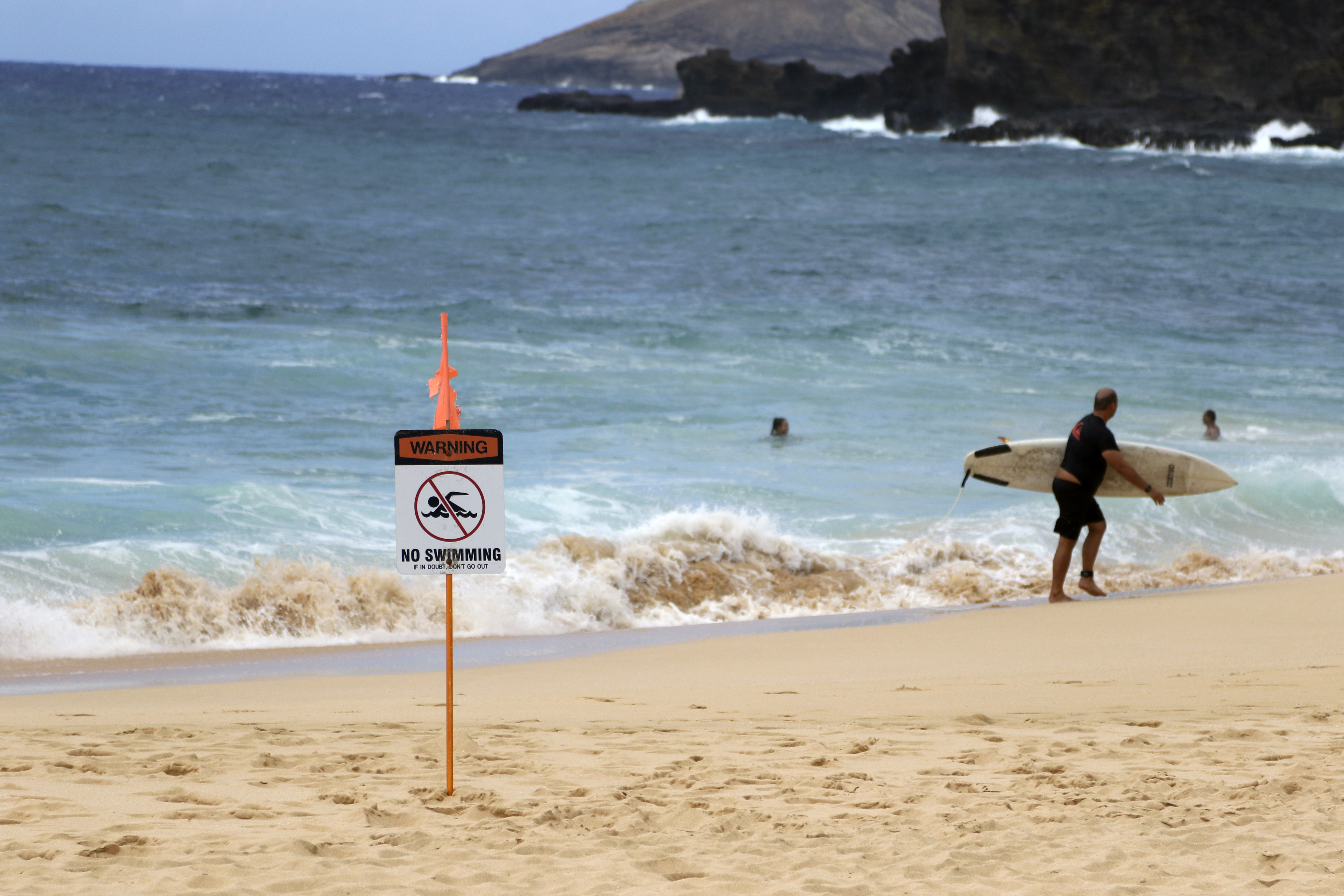 A surfer leaves the water in Honolulu, Saturday, July 25, 2020, as Hurricane Douglas approaches. (Photo: Caleb Jones, AP Photo)