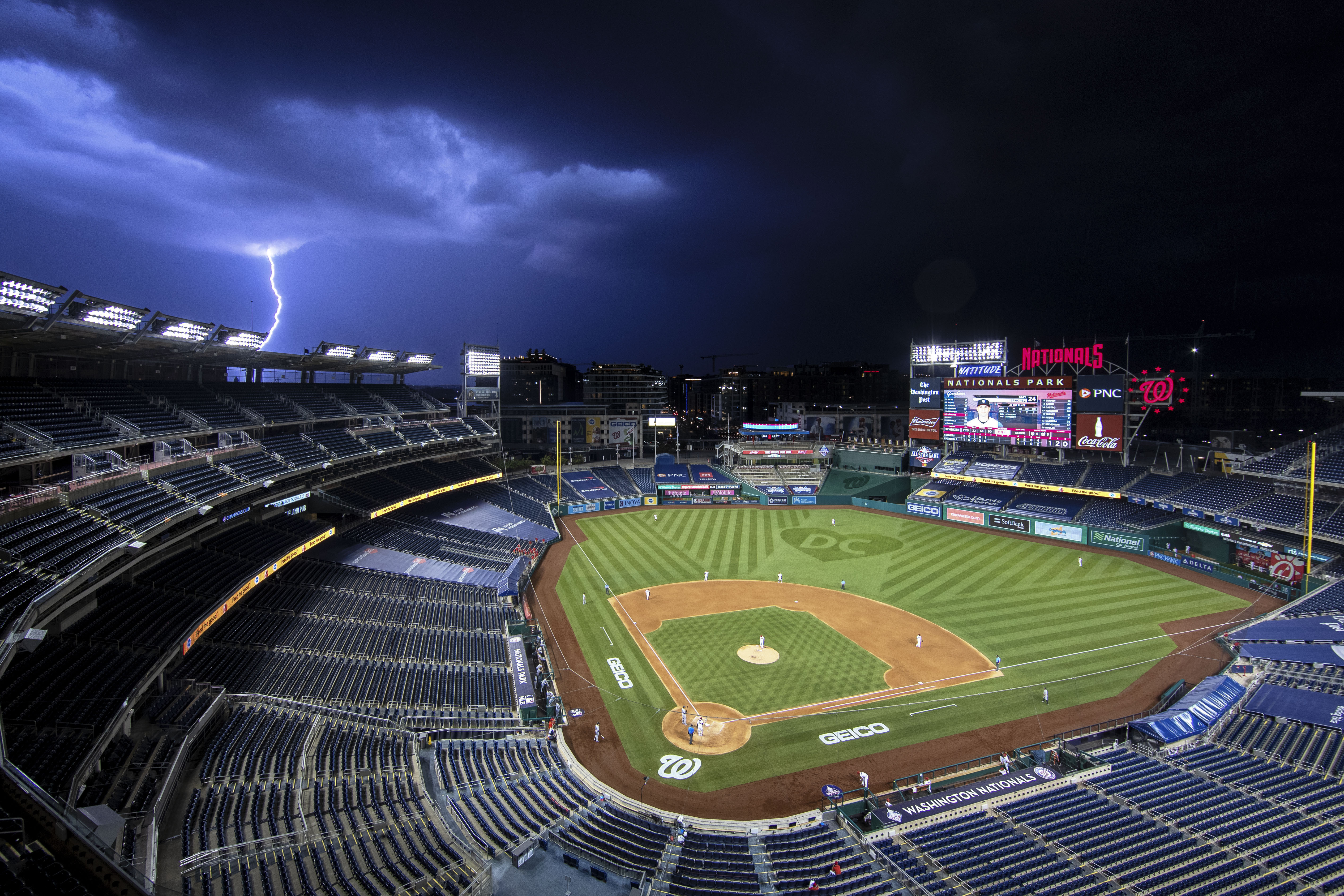 A bolt of lightning comes down from the clouds during the sixth inning of an opening day baseball game between the Washington Nationals and the New York Yankees at Nationals Park, Thursday, July 23, 2020, in Washington. (AP Photo/Alex Brandon)