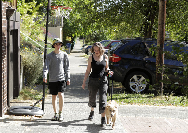 Jennifer Haller, right, the first person to receive a trial dose of a COVID-19 vaccine, walks with her son Hayden, 16, and their dog Meg, Sunday, July 19, 2020, in Seattle. (Photo: Ted S. Warren)