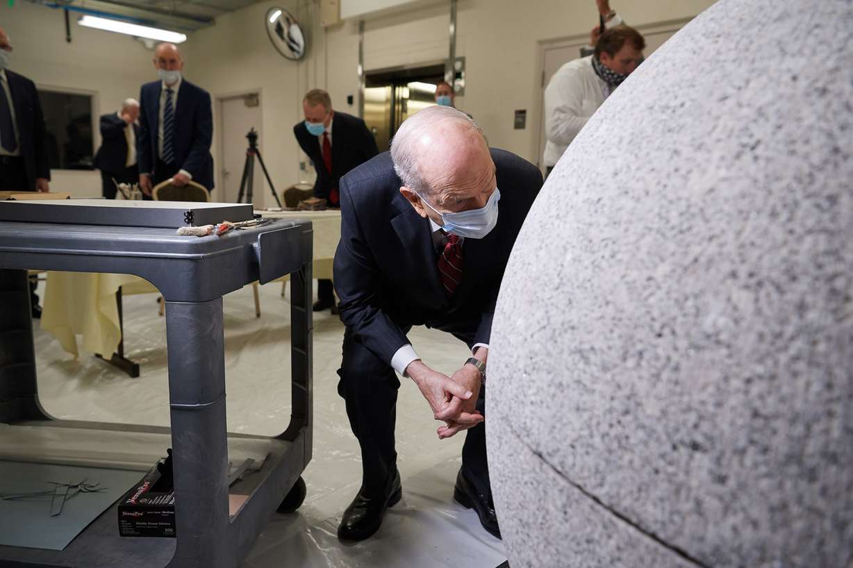President Russell M. Nelson, of the Church of Jesus Christ of Latter-day Saints, peaks inside a capstone of the Salt Lake Temple on the loading dock of the Church History Library on May 20, 2020.